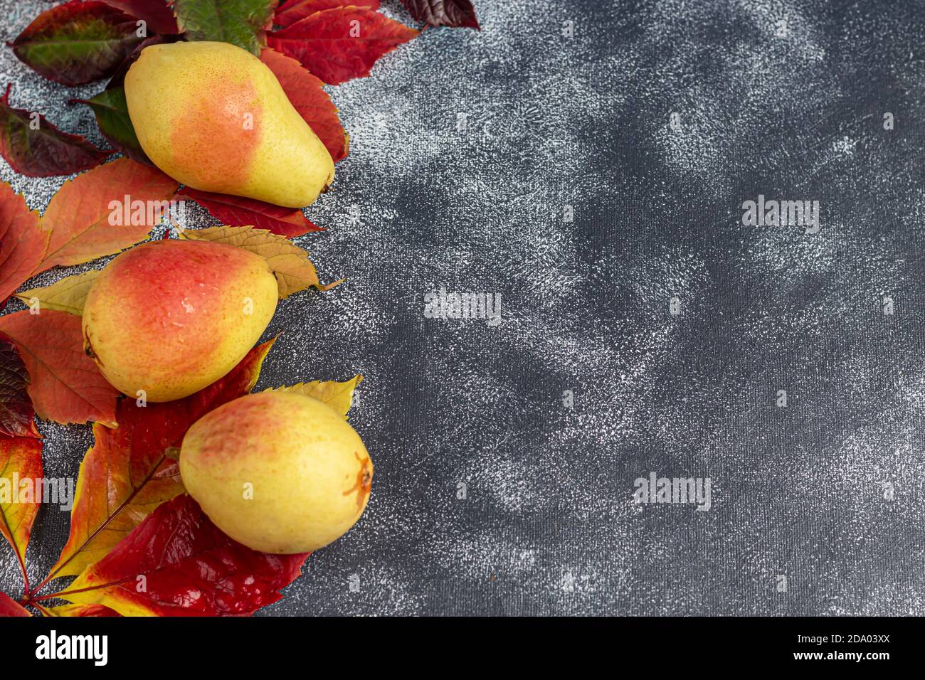 Pere su uno sfondo chiaro. Concetto autunnale. Nelle vicinanze si trovano patatine e noci di pera secca. Spazio di copia. Foto Stock