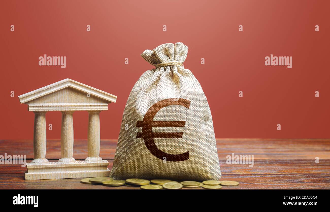 Borsa di denaro in euro e edificio bancario/governativo. Riscossione delle imposte e budget. Debito statale. PIL e PNL. Politica monetaria. Supportare le aziende in tempi di Foto Stock