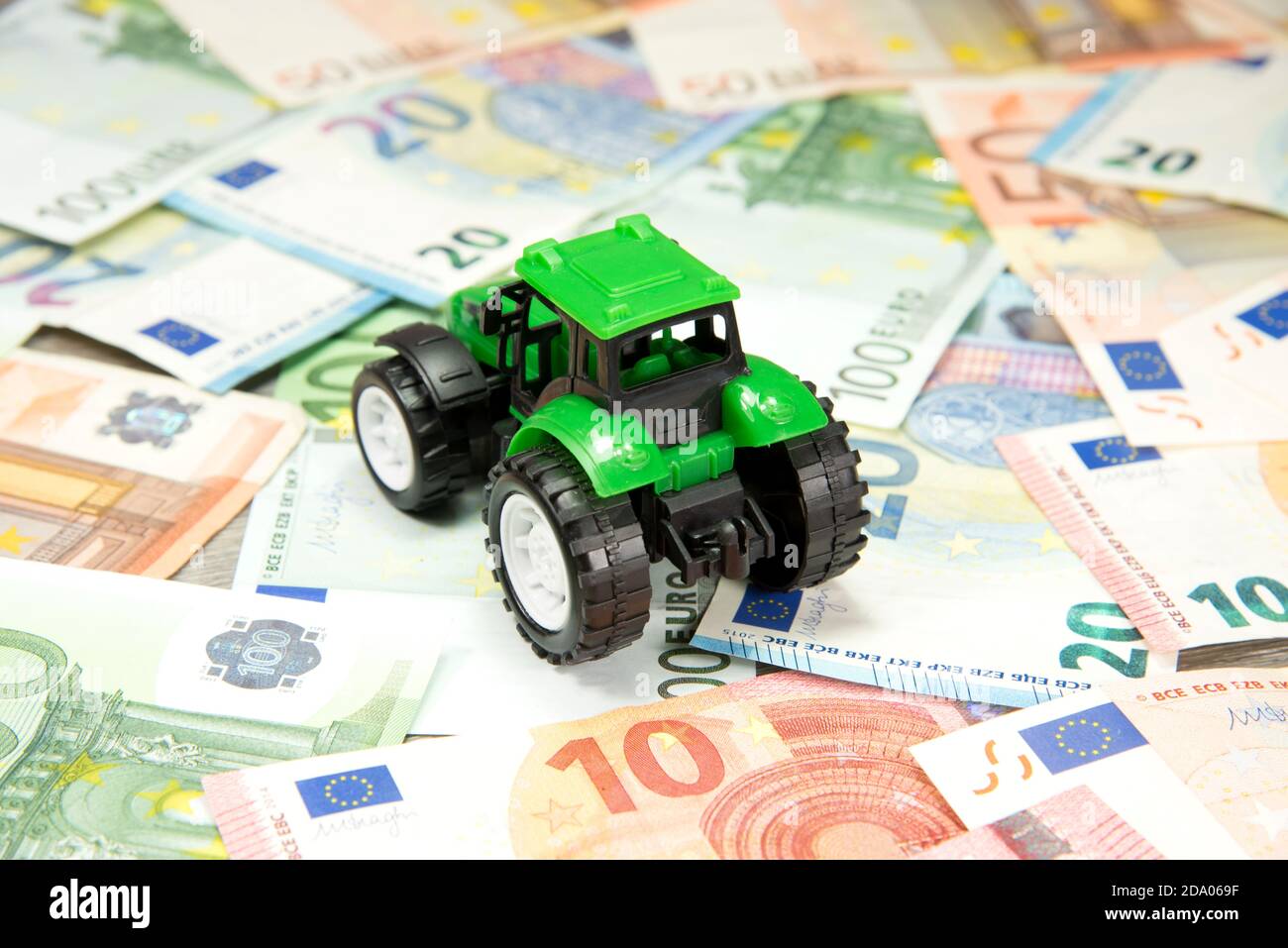 Un trattore e denaro in euro Foto Stock