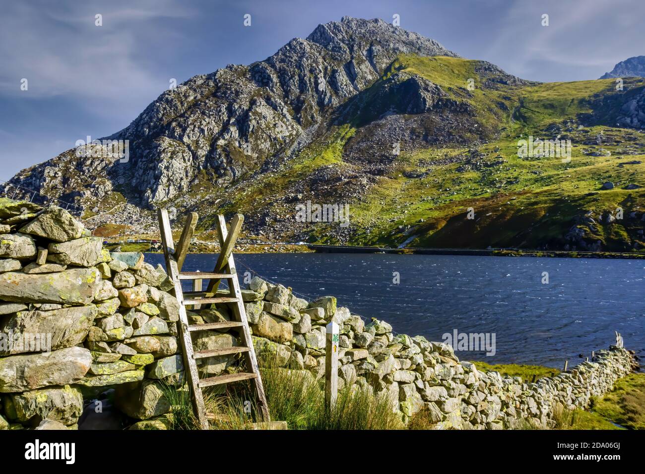 Stile di legno vicino ad un lago e montagna (Llyn Ogwen e Tryfan, Snowdonia, Galles) Foto Stock