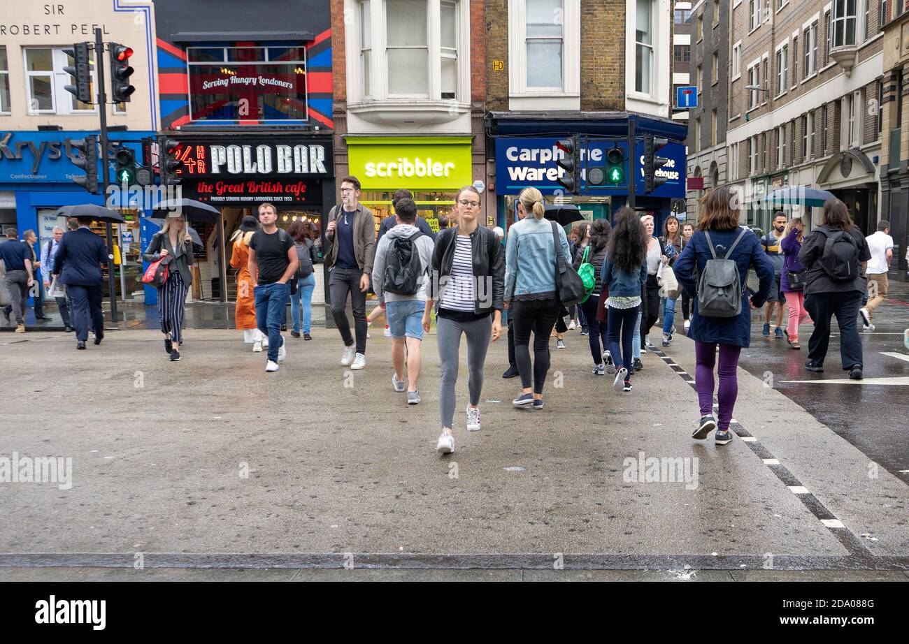 Persone che attraversano la strada al semaforo in Bishopsgate fuori Stazione di Liverpool Street Foto Stock