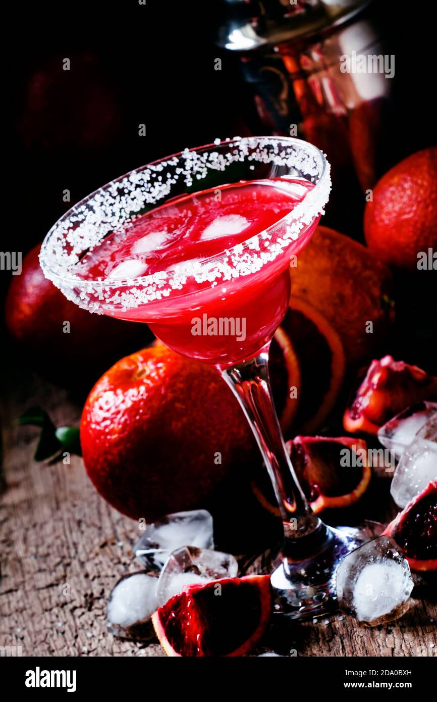 Cocktail alcolico Negroni con gin, Campari, vermouth rosso, arancio sangue  e cubetti di ghiaccio, fondo nero, fuoco selettivo Foto stock - Alamy