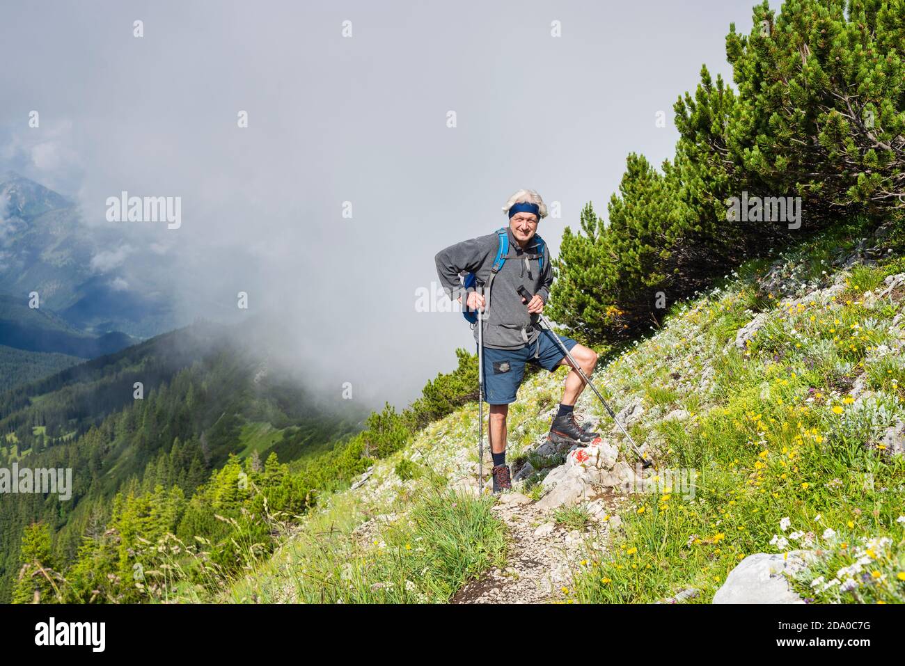 Anziano escursionista sul sentiero lungo il crinale acuto delle Blue Mountains con le nuvole che si innalzano nell'aria, Baviera, Germania Foto Stock