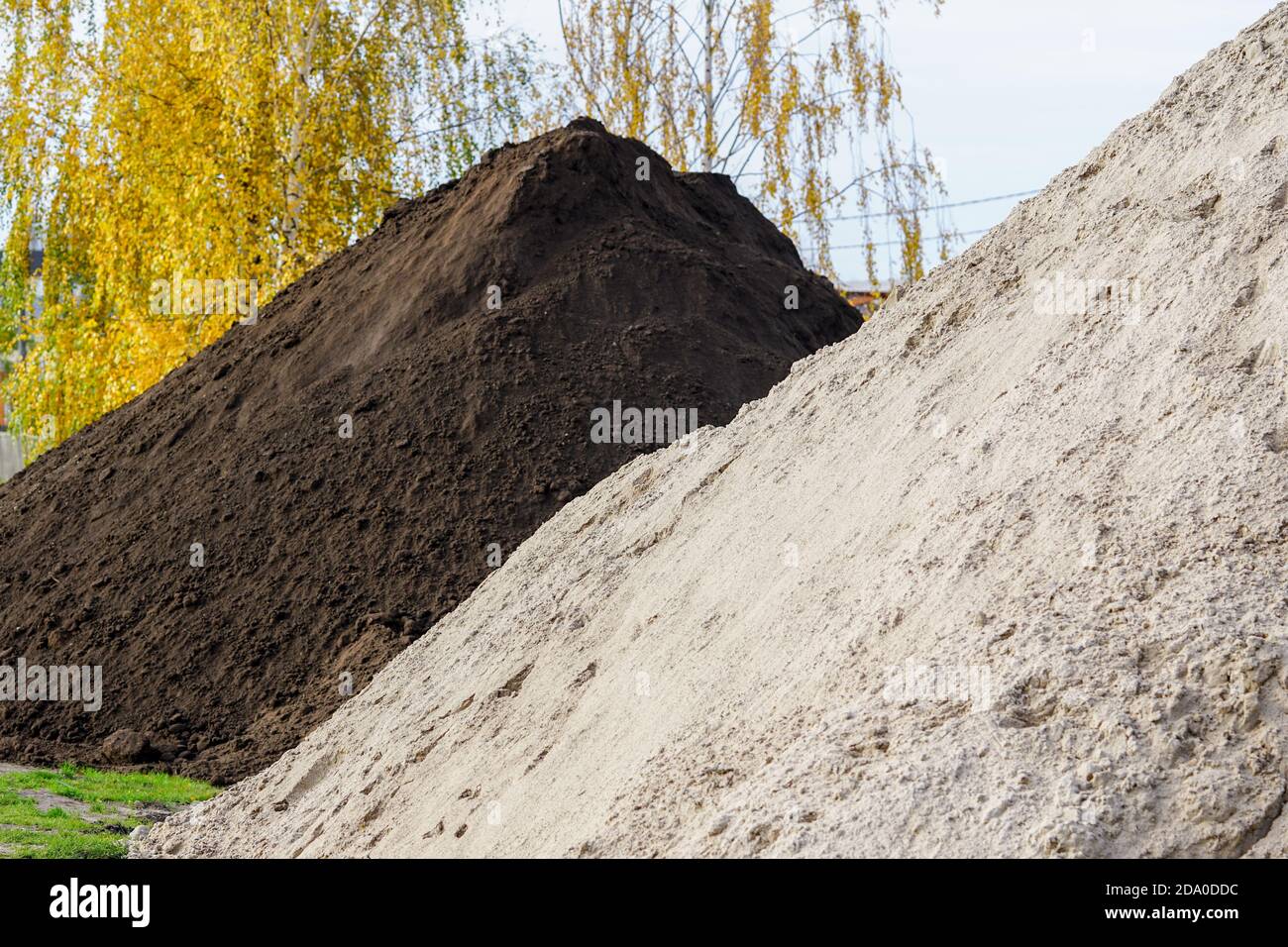 grandi terreni e pali di sabbia nell'area dei materiali da costruzione Foto Stock