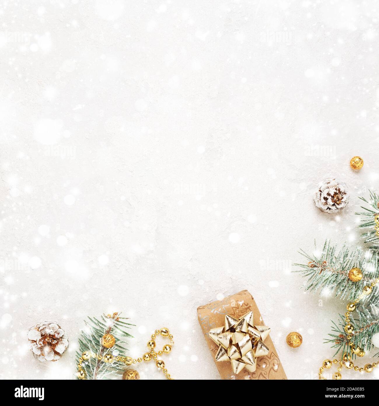 Regalo di Natale, rametti d'abete verde, decorazione d'oro su fondo bianco nevoso. Spazio di copia. New Year Flat Lay. Foto Stock Regalo di Natale, rametti d'abete verde, decorazione d'oro su fondo bianco nevoso. Spazio di copia. New Year Flat Lay. Foto Stock