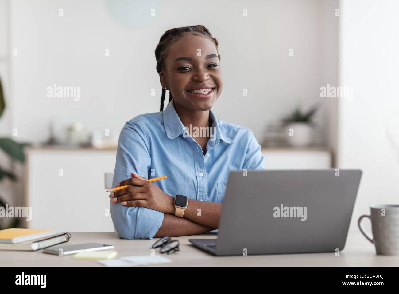 Lavorare per gli studenti. Black Young Female Office Employee in posa sul posto di lavoro Foto Stock