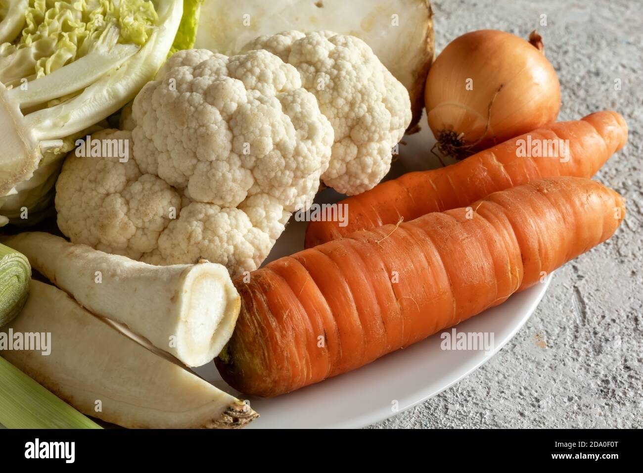 Primi piatti di carote, cavolfiore, radice di prezzemolo e altri ingredienti per preparare un brodo vegetale o una zuppa Foto Stock