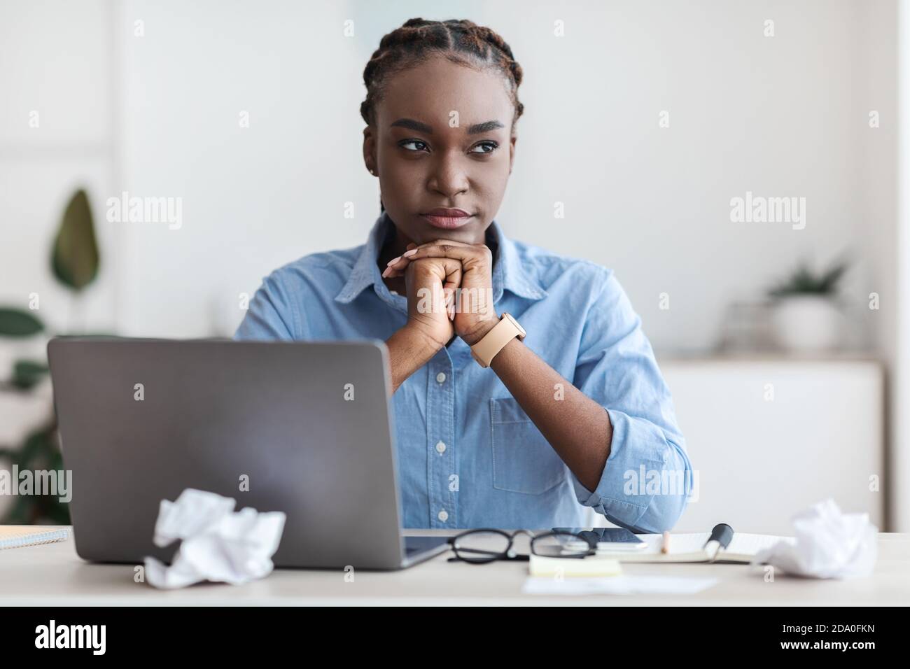 Problema di inspirazione. Donna freelance nera pensierosa che si siede sul posto di lavoro in ufficio domestico Foto Stock
