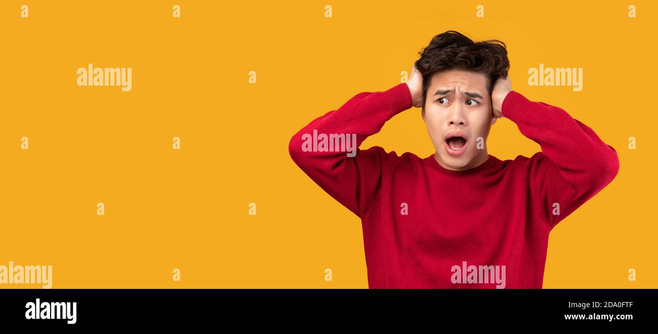 Sorpreso asiatico ragazzo vedendo scioccante pubblicità, panorama Foto Stock