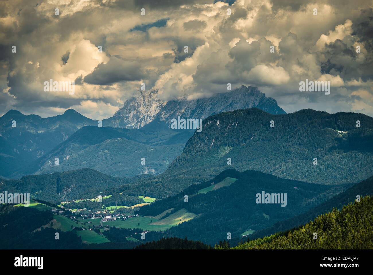 Nuvole di cumuli illuminate in modo drammatico sopra le scogliere e le cime delle montagne Kaiser e la valle di Thiersee vicino Kufstein, Tirolo, Austria Foto Stock