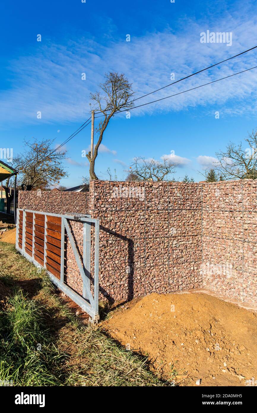 Costruzione di una casa di famiglia. Recinzione in pietra. Al mattino sul  cantiere. Pietre gabbate parete di Gabion Foto stock - Alamy