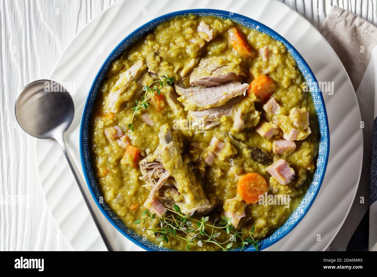 zuppa finlandese di piselli verdi con costolette di maiale e prosciutto in una ciotola blu, vista orizzontale dall'alto, piatto, primo piano Foto Stock