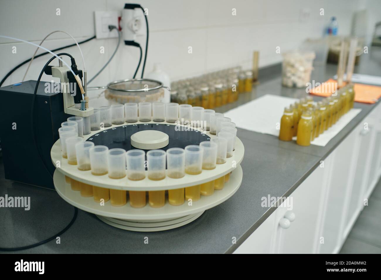 Angolo elevato di provette in plastica con campioni di vari liquidi posto sul tavolo in un laboratorio moderno Foto Stock