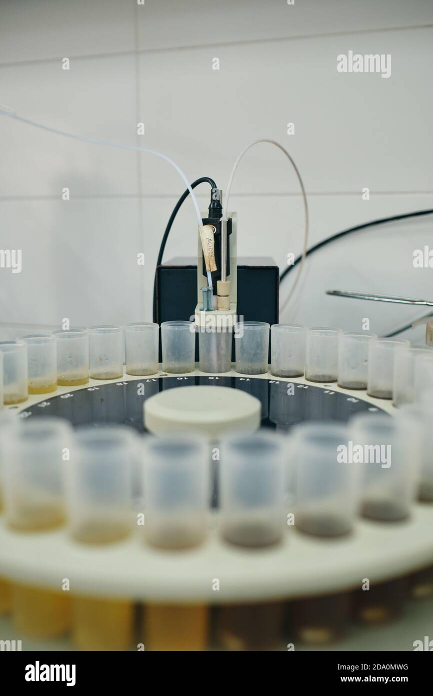 Angolo elevato di provette in plastica con campioni di vari liquidi posto sul tavolo in un laboratorio moderno Foto Stock