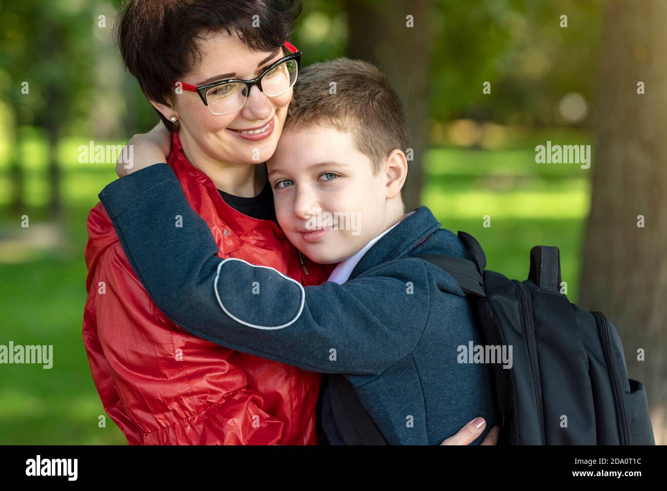 Mamma e figlio felici si abbracciano. Amore materno, parenting, rapporti familiari di fiducia. Foto Stock