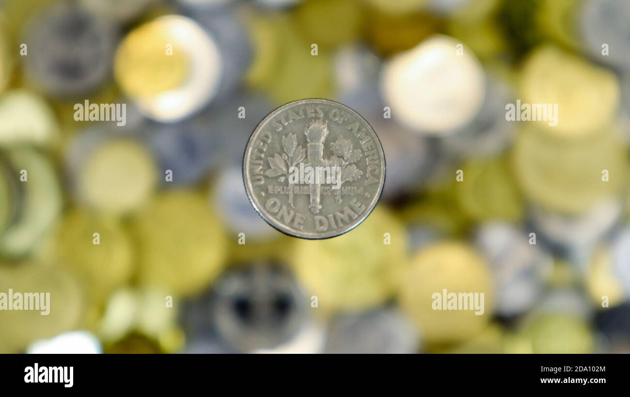 Un primo piano mostra una moneta da 10 cent o 0.1 dollari USA. Questo è denaro. Sfondo di denaro sfocato. Il dime da 10 cent è il più piccolo di tutte le monete. I revers Foto Stock