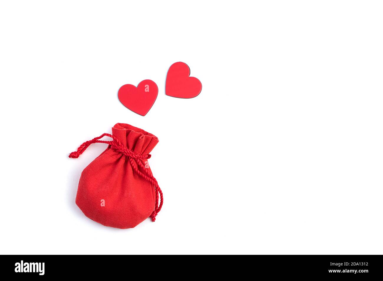 Due cuori rossi volano da una borsa regalo su uno sfondo chiaro. Foto Stock