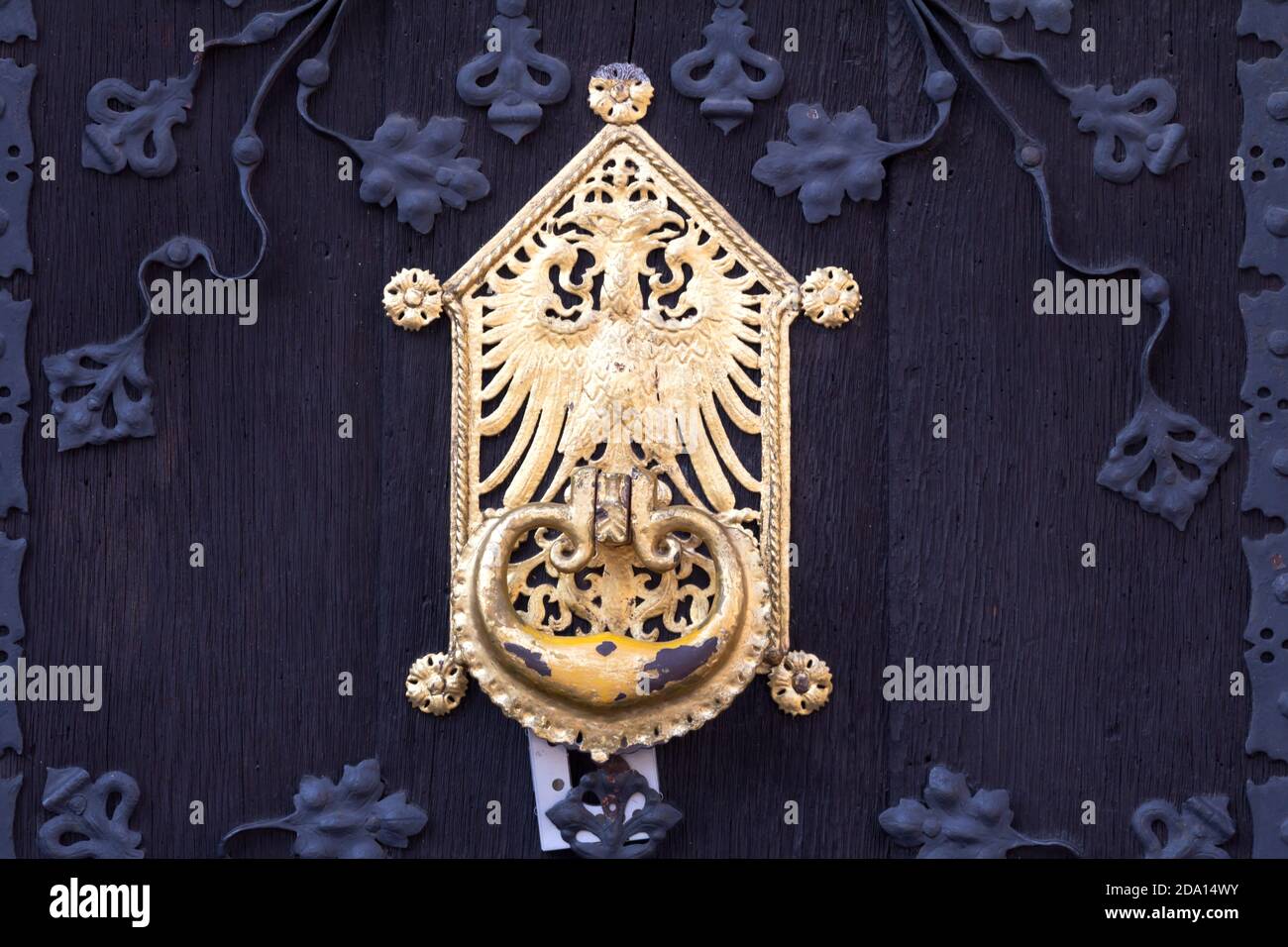 Primo piano di una tradizionale porta tedesca nera con oro accenti della manopola della portiera Foto Stock
