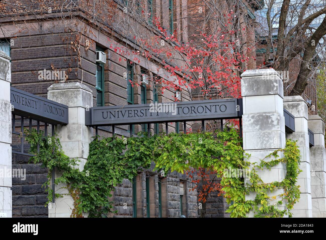 Toronto, Canada - 5 novembre 2020: Il cancello d'ingresso al campus principale dell'Università di Toronto, con un grande vecchio edificio accademico sul retro Foto Stock