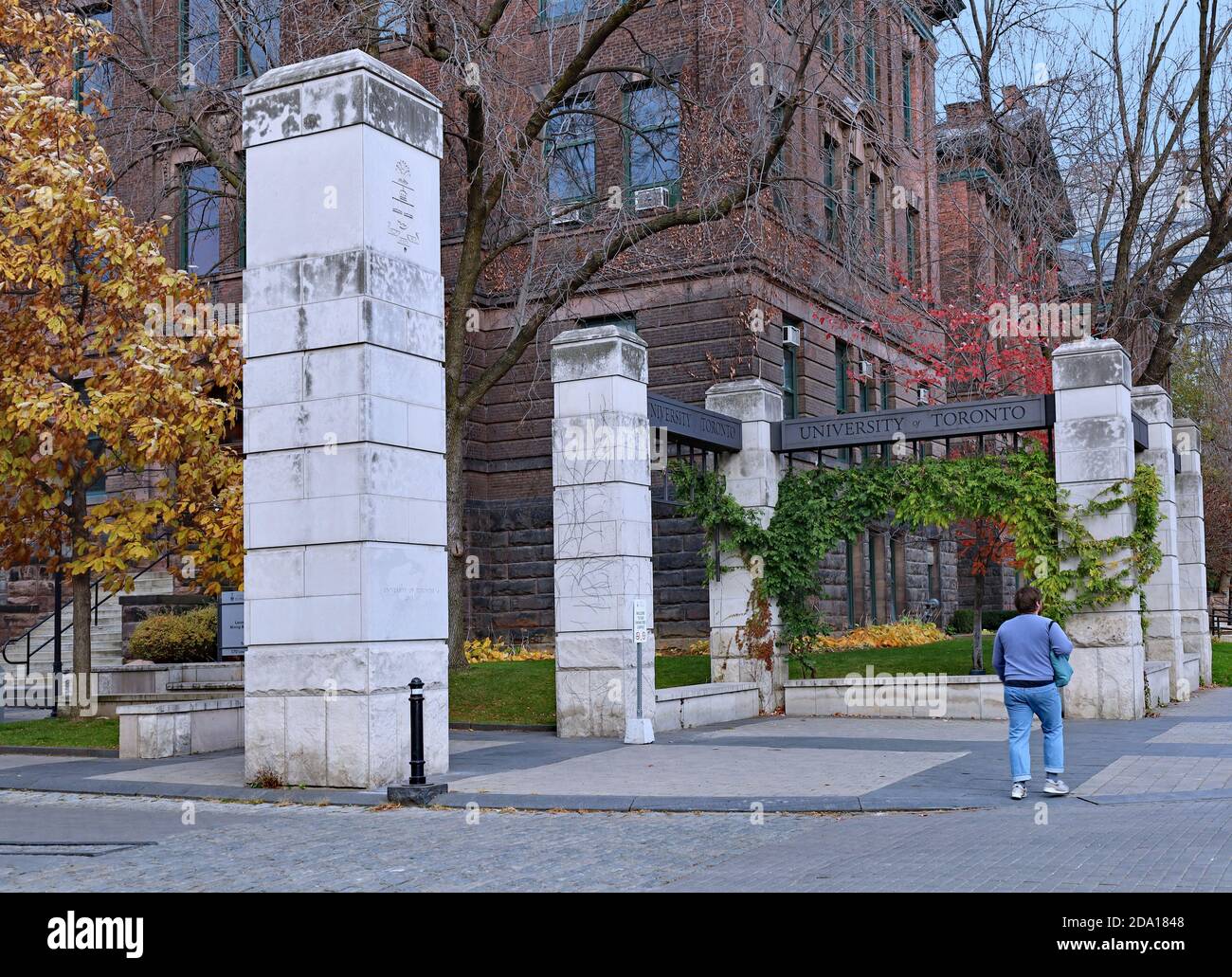 Toronto, Canada - 5 novembre 2020: Il cancello d'ingresso al campus principale dell'Università di Toronto, con un grande vecchio edificio accademico sul retro Foto Stock