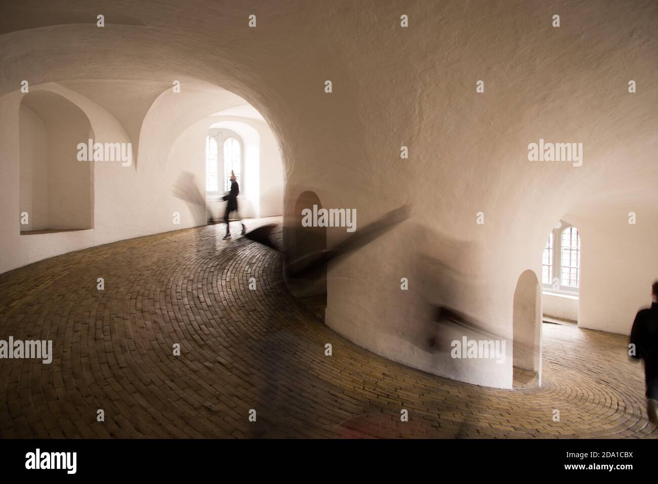 I bambini della scuola si divertono mentre corrono lungo Rundetaarn, lo storico osservatorio di Copenhagen, una grande torre rotonda situata nel centro della città. Foto Stock