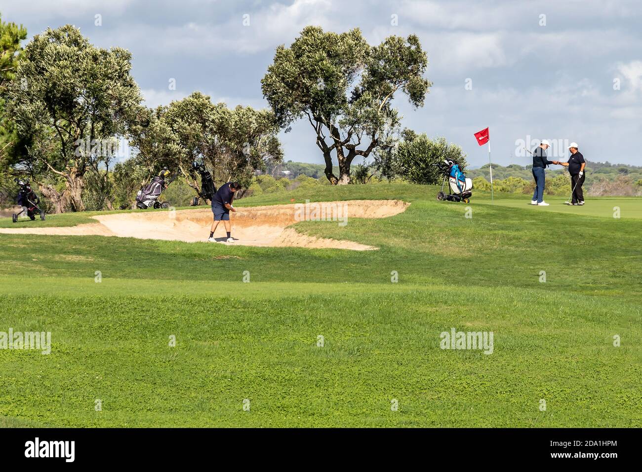Huelva, Spagna - 8 novembre 2020: Tre uomini maturi giocano a golf nel villaggio di el Ropido, Huelva, Andalusia, Spagna Foto Stock