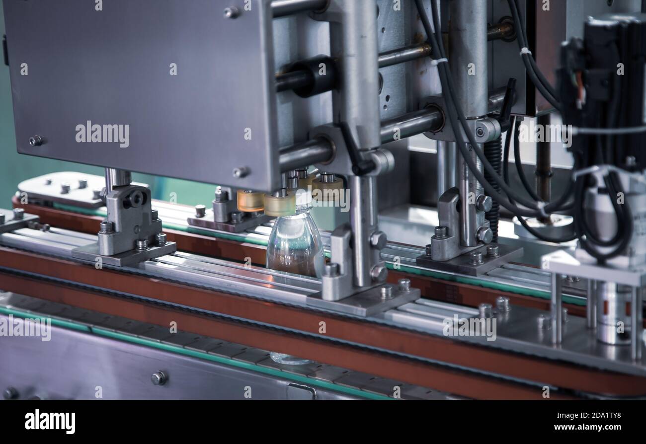 Macchina per il riempimento e l'imballaggio di bottiglie liquide nell'industria alimentare Foto Stock