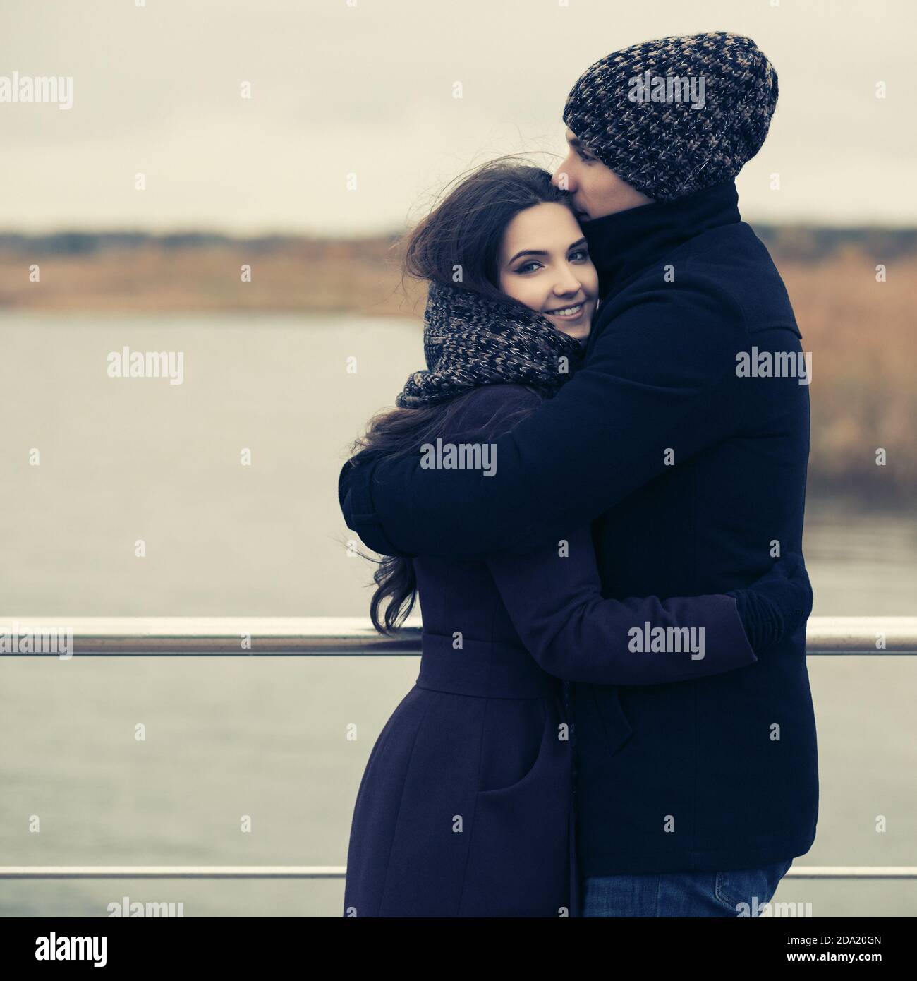 Felice giovane coppia di moda in amore abbracciando outdoor elegante uomo e donna in classico cappotti bania e sciarpa Foto Stock