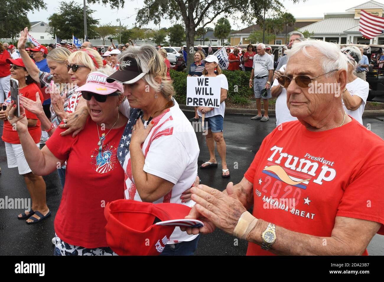 I villaggi, Stati Uniti. 8 novembre 2020. La gente prega per il presidente degli Stati Uniti Donald Trump in una sfilata di cart a sostegno del presidente il giorno dopo che Trump ha perso le elezioni presidenziali degli Stati Uniti 2020 all'ex vice presidente Joe Biden. Prima della sfilata, i sostenitori cantavano canzoni patriottiche, pregavano per il signor Trump e raccolsero donazioni per le spese legali di Trump per contestare i risultati delle elezioni. Credit: SOPA Images Limited/Alamy Live News Foto Stock