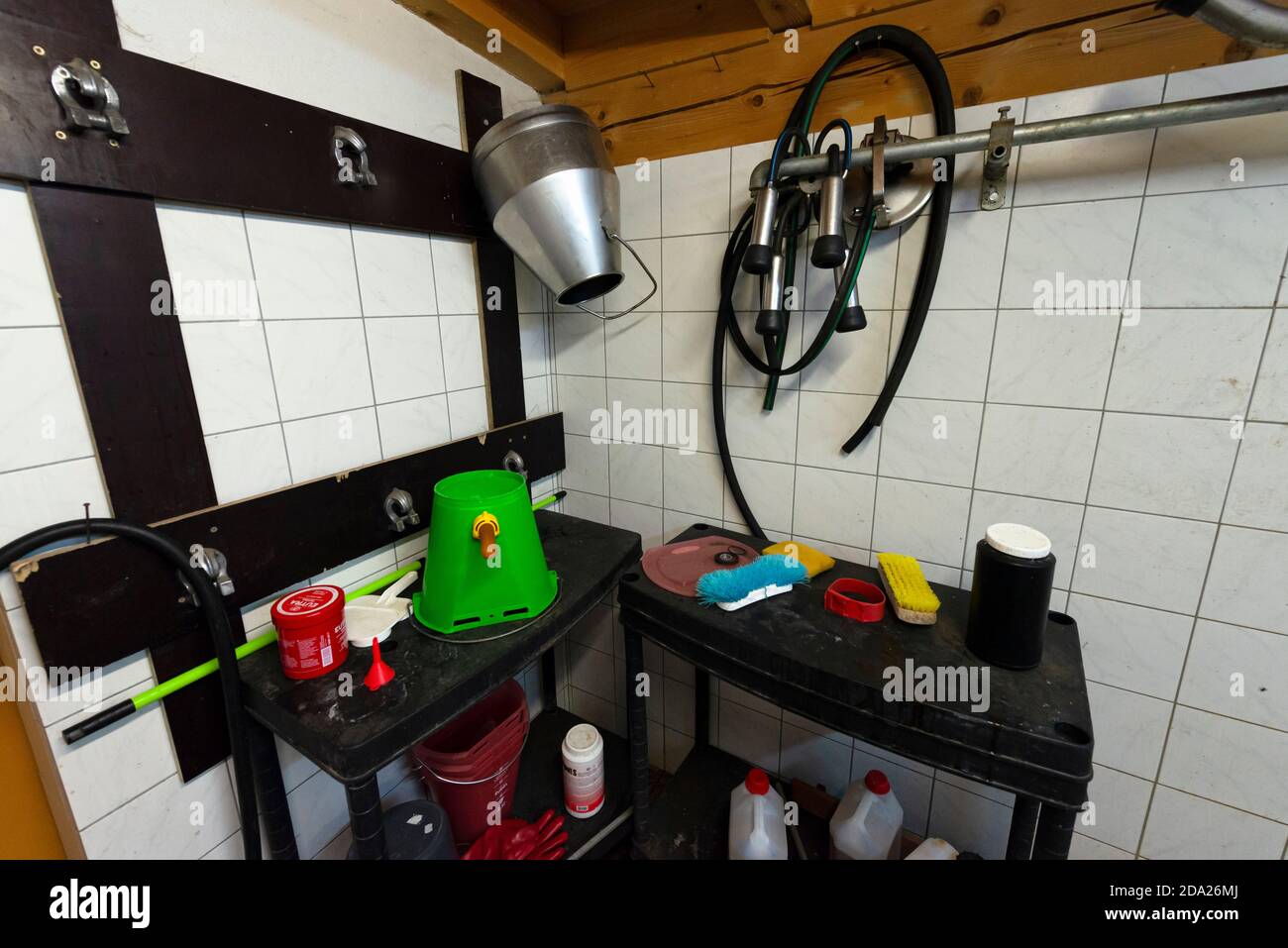 Secchi, manichette e attrezzature per mungere le vacche di fronte alle pareti di piastrelle bianche, Ackernalm, Tirolo, Austria Foto Stock