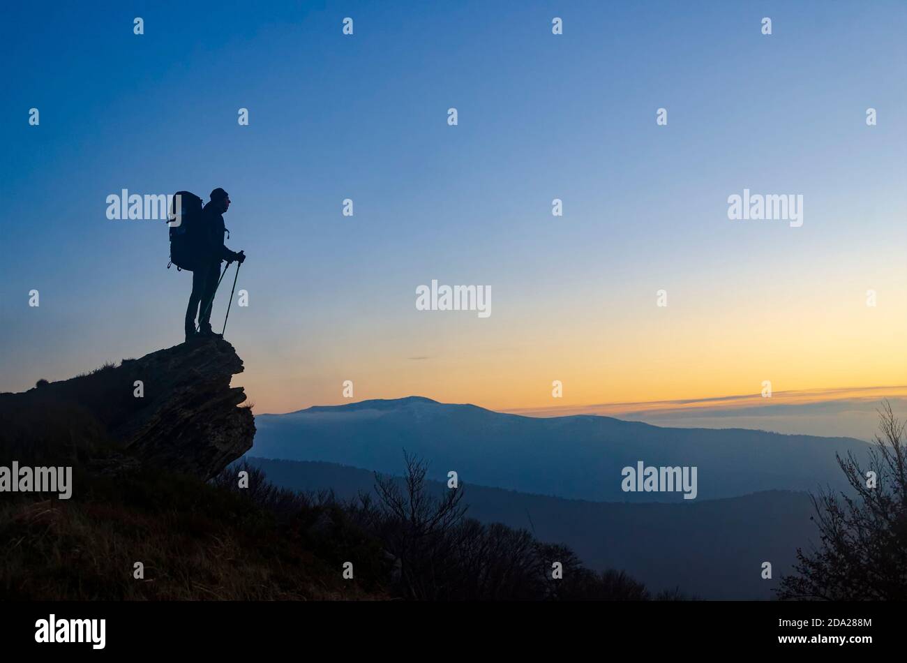 Escursionista con zaino sulla cima della montagna goditi il tramonto. Simbolo del successo della vita. Foto Stock