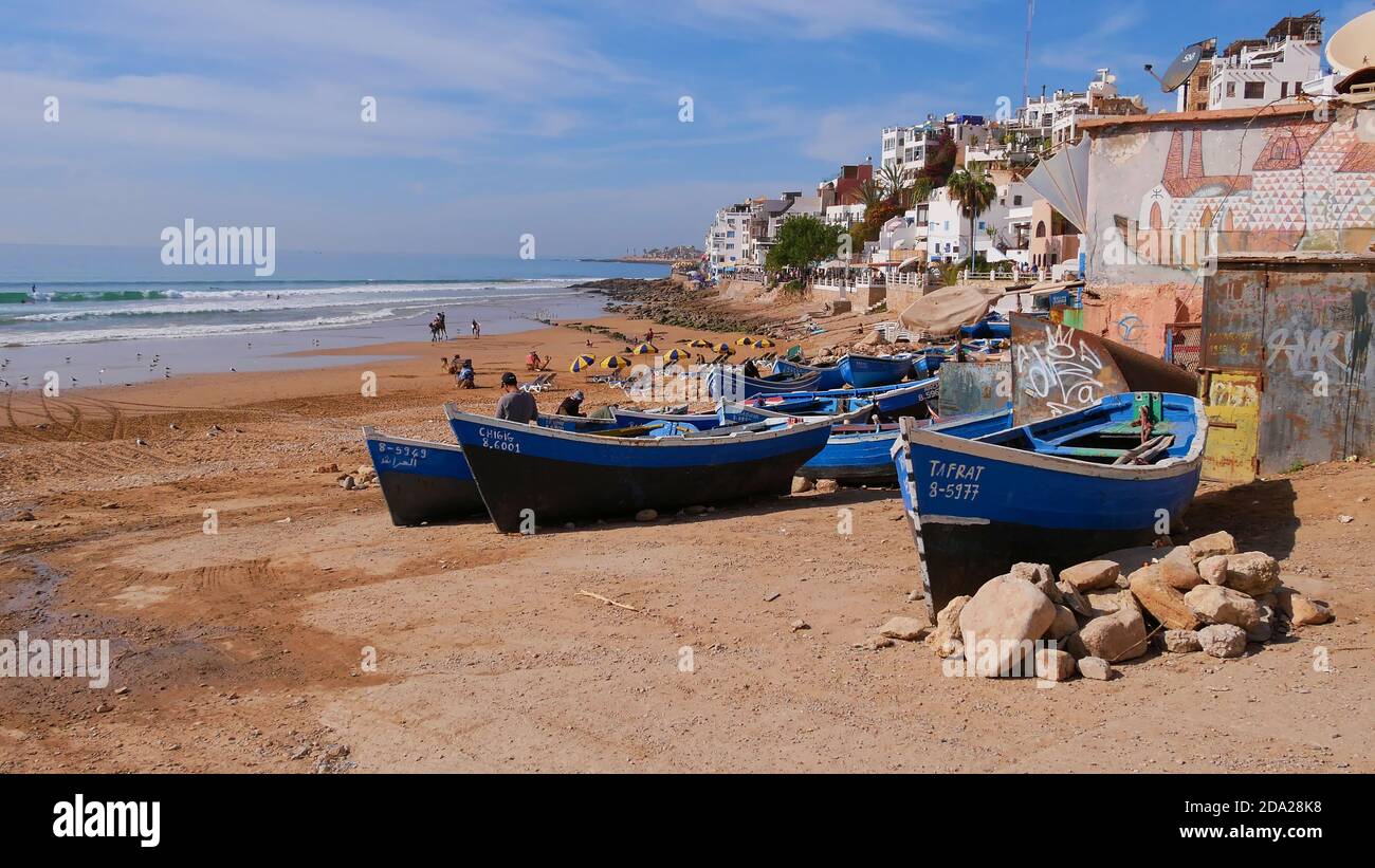 Taghazout, Marocco - 01/03/2020: Piccole barche da pesca sulla bellissima spiaggia del villaggio di Taghazout, un popolare luogo di surf e destinazione turistica. Foto Stock
