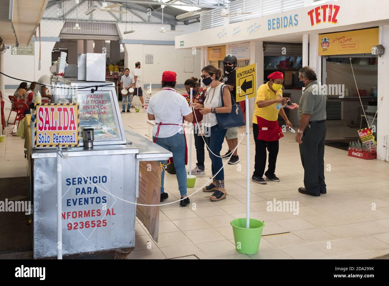 Dipendenti che prendono le temperature dei clienti in un piccolo ristorante , quartiere Santiago , Merida , Messico Foto Stock