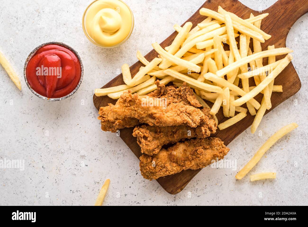 Pesce e patatine. Filetto di pesce fritto e con patatine fritte su fondo bianco con salse. Tradizionale cibo di strada britannico. Foto Stock