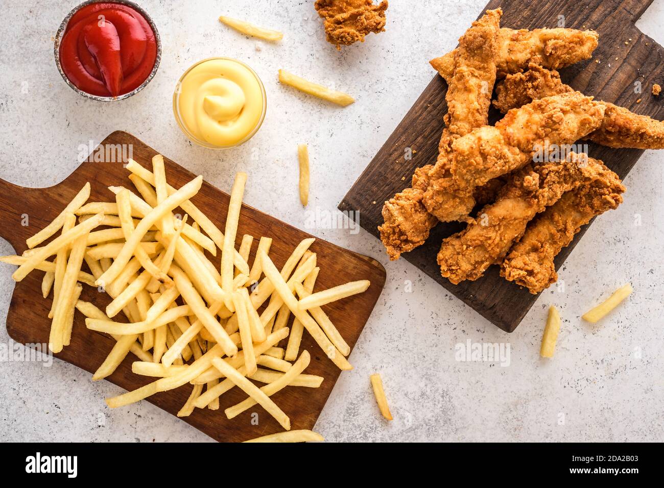 Pesce e patatine. Filetto di pesce fritto e con patatine fritte su fondo bianco con salse. Tradizionale cibo di strada britannico. Foto Stock