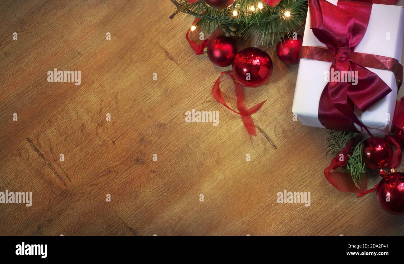 Vista dall'alto di uno sfondo decorato a Natale con un regalo, un albero e luci lampeggianti su un tavolo di legno. Con spazio per la copia per i desideri del tuo nuovo anno, Foto Stock
