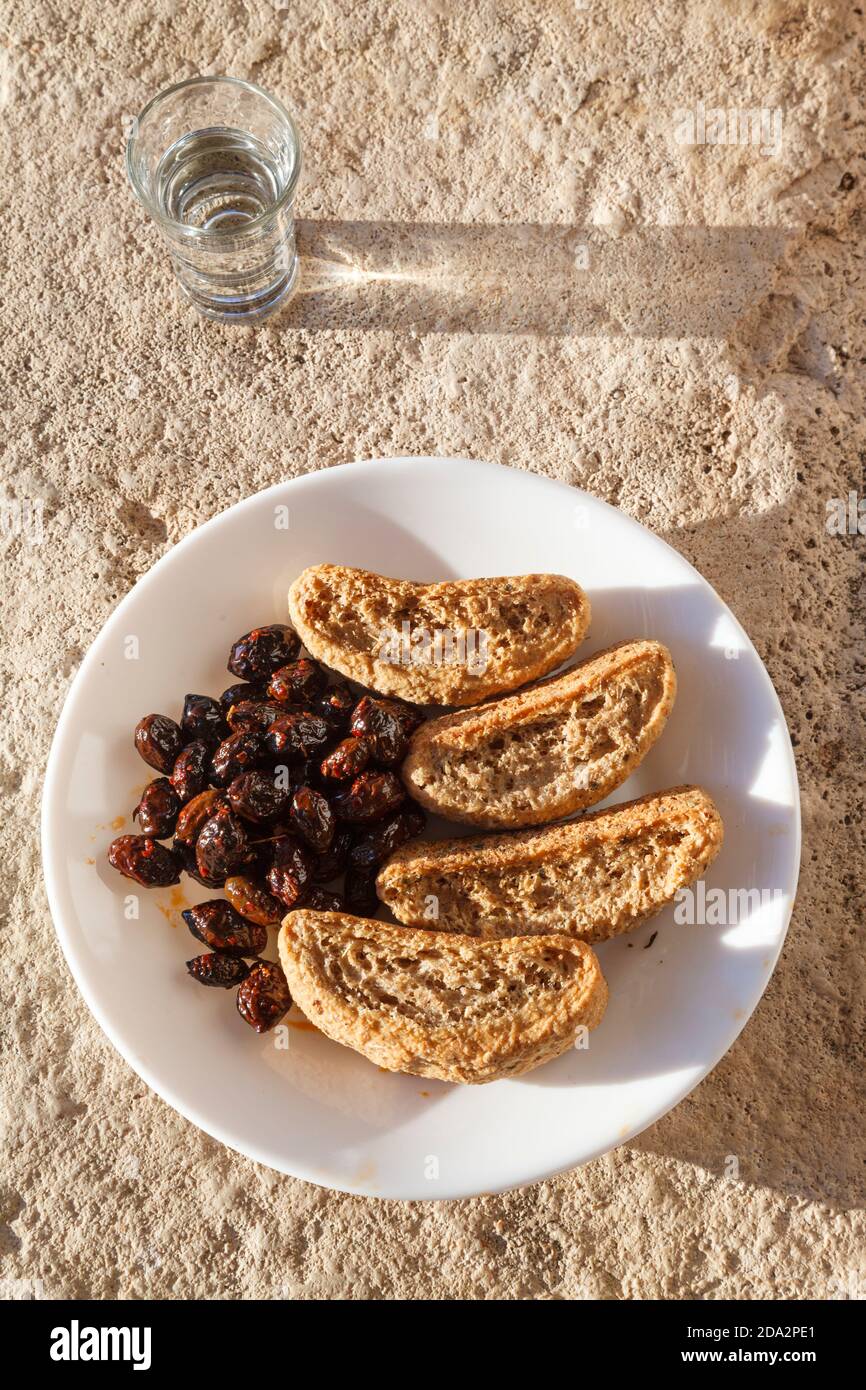 Cretese, olive e tsikoudia (raki), un delizioso pasto snack come spesso offerto a Creta. Tutti e tre i prodotti sono di tipica cucina cretese. Foto Stock