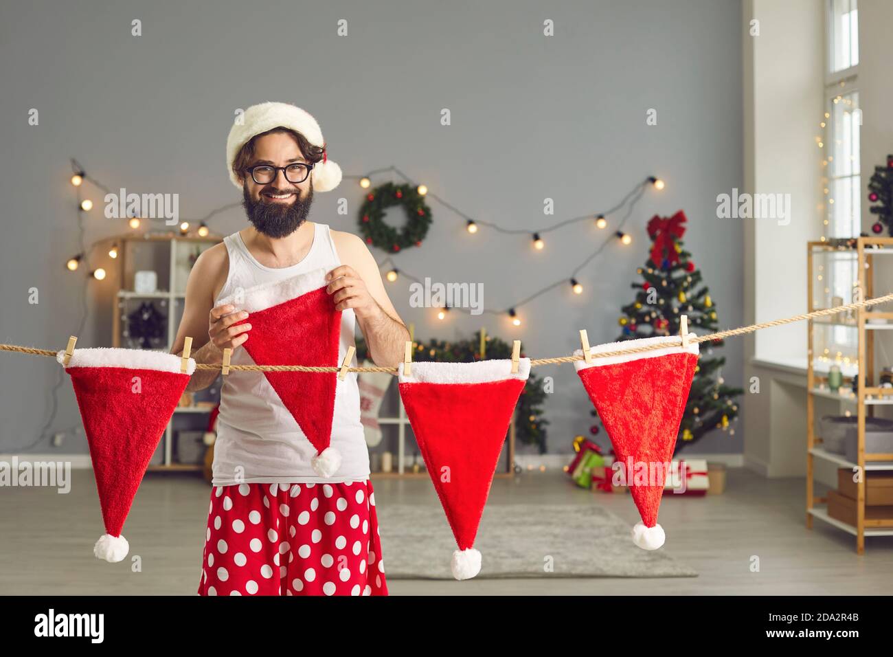 Divertente Natale Elf o Santa giovane prepararsi per l'inverno vacanze e fare lavanderia Foto Stock