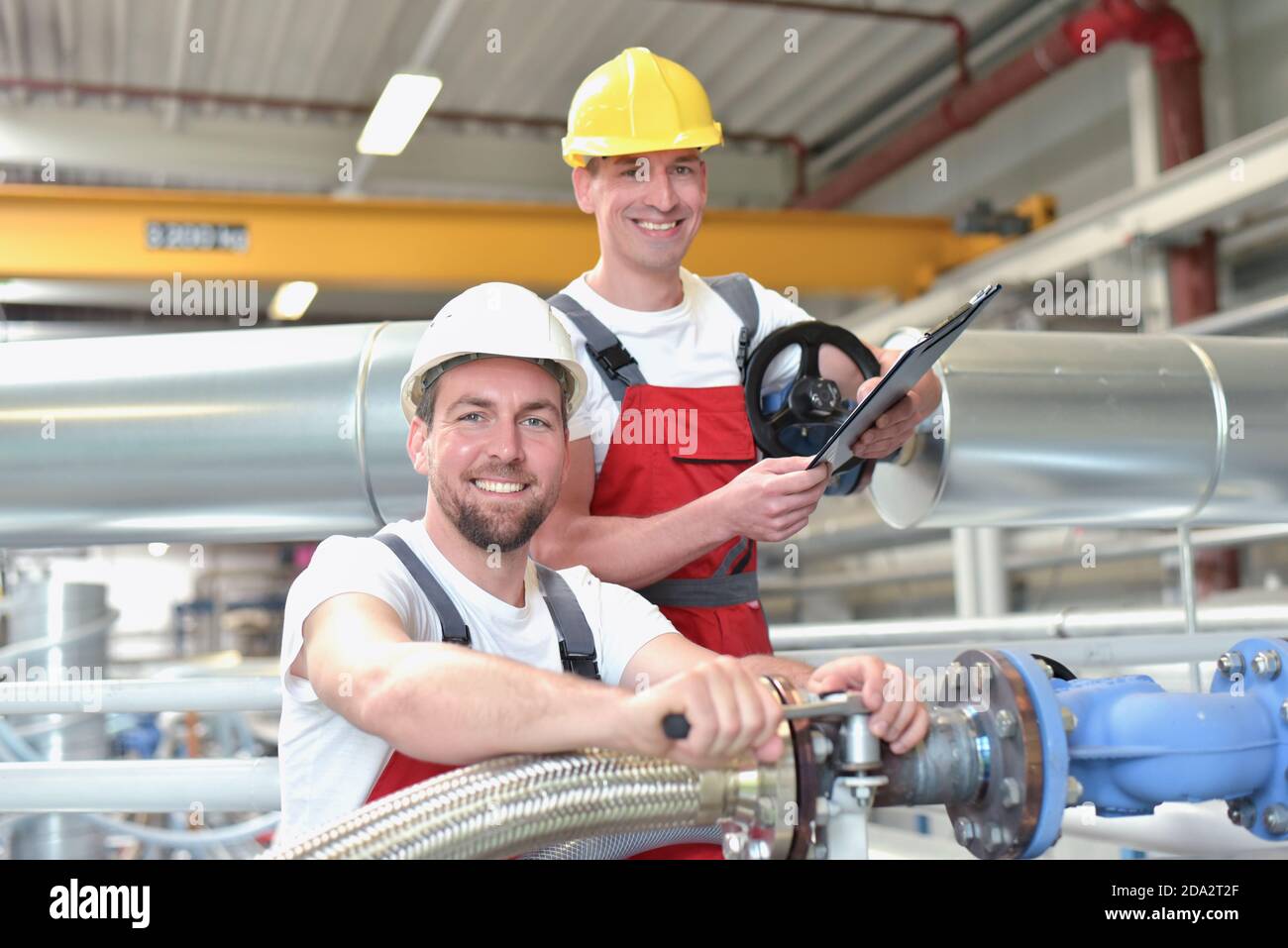 Riparazione meccanica di una macchina in un moderno impianto industriale - professione e lavoro di squadra - Ritratto gruppo operaio Foto Stock