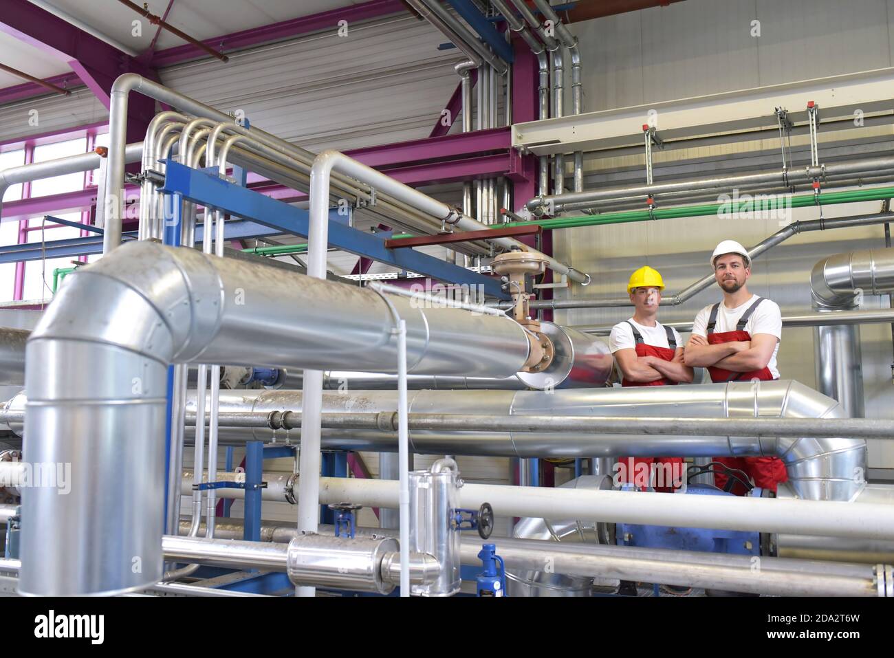 Riparazione meccanica di una macchina in un moderno impianto industriale - professione e lavoro di squadra - Ritratto gruppo operaio Foto Stock