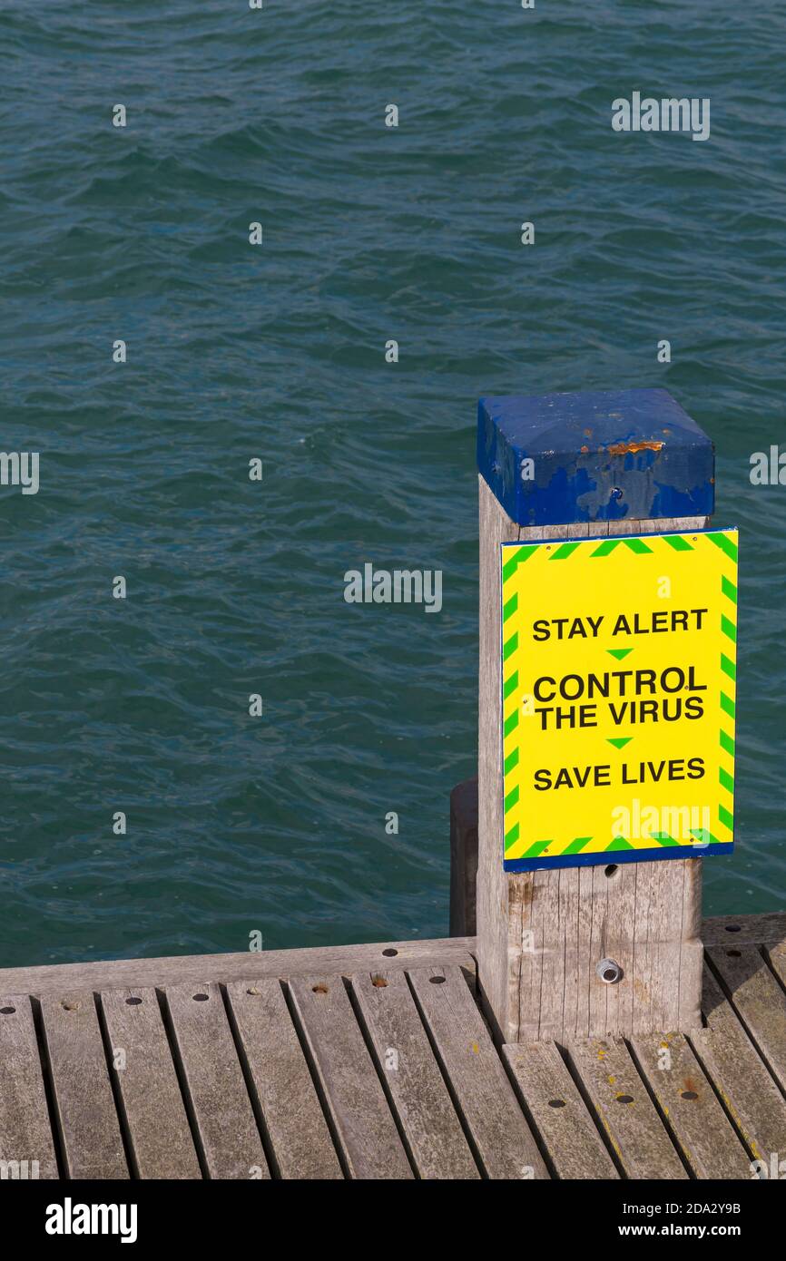 Resta vigile il controllo del virus salvare vite segno accanto al pontile sul molo Swanage a Swanage, Dorset UK nel mese di ottobre Foto Stock