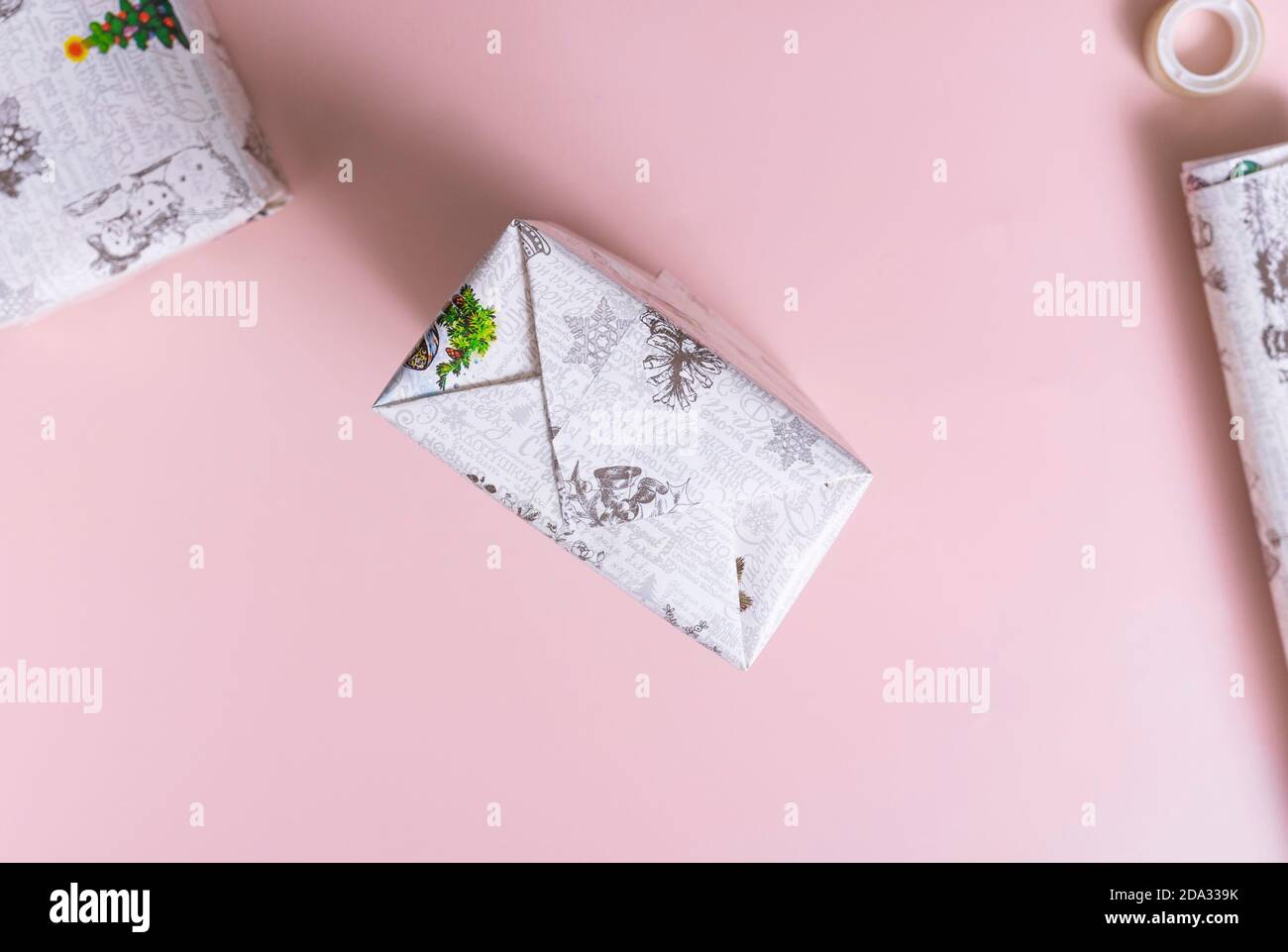 Passaggio 5. Similmente, sigilli il lato opposto del regalo. Far scorrere le dita lungo i bordi del rettangolo per rendere più chiara la forma della confezione. Foto Stock