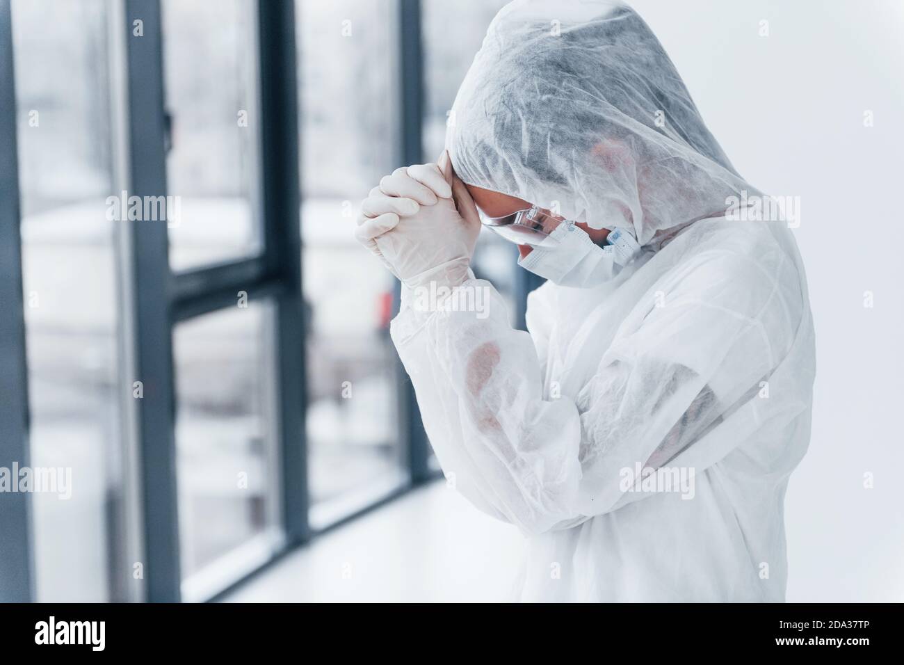Sentirsi male, stanco e depresso. Ritratto di dottoressa scienziato in camice da laboratorio, occhiali difensivi e maschera Foto Stock