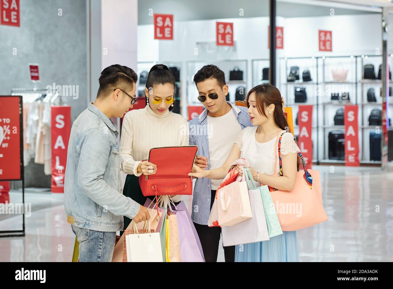 Persone che guardano la borsa in pelle rossa Foto Stock
