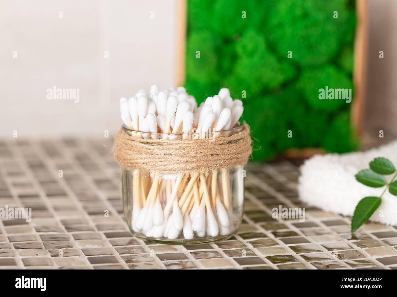 bastoncini di cotone in vaso di vetro sul banco del bagno. Foto Stock