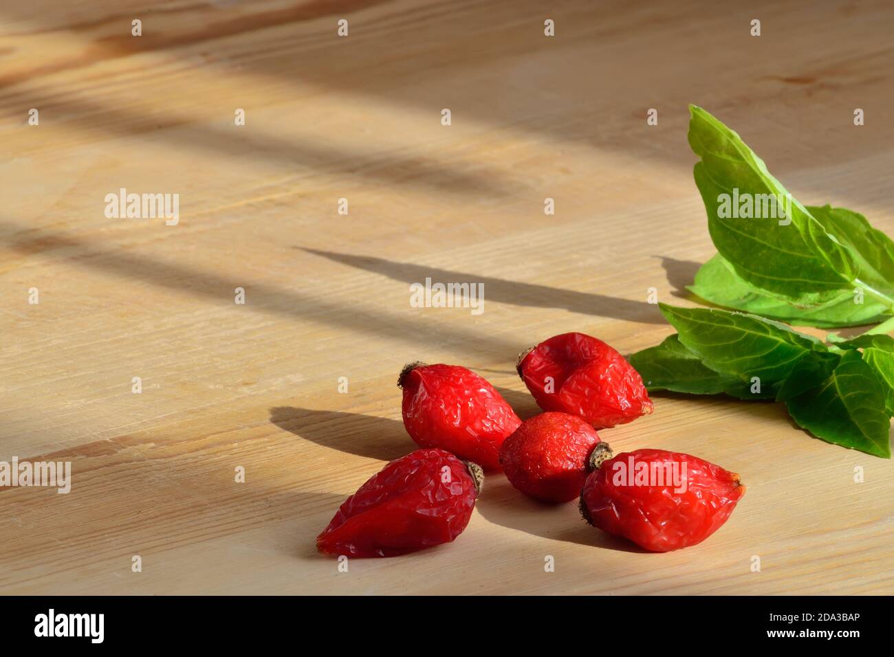 Arachee di rose e basilico su sfondo di legno da vicino. Spazio di copia Foto Stock