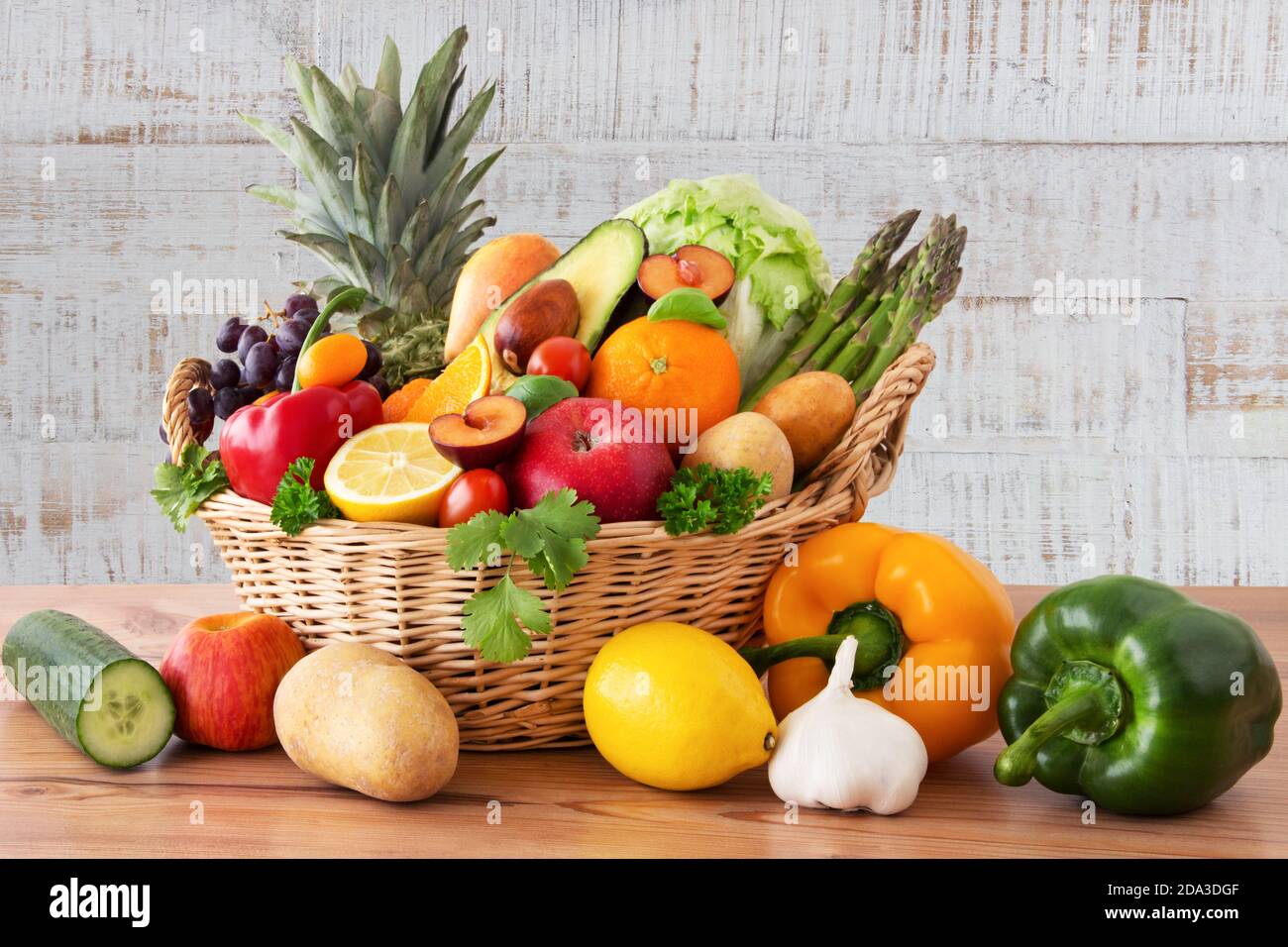 Obst und Gemüse in einem Korb auf Holz Hintergrund Foto Stock