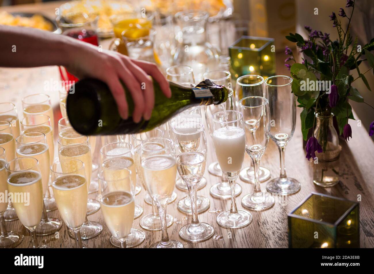 Versare champagne in flauti di champagne in una festa. Foto Stock