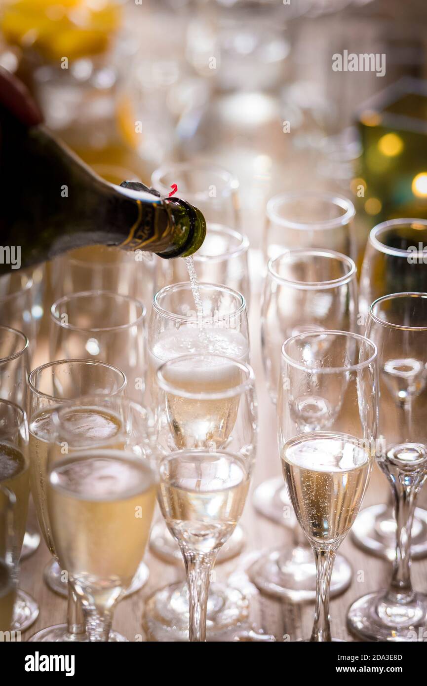 Versare champagne in flauti di champagne in una festa. Foto Stock