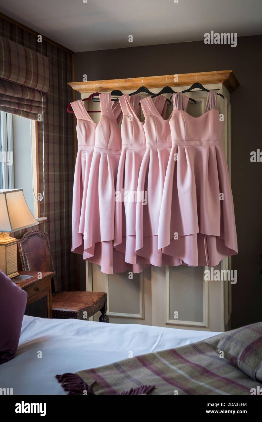 Abiti da sposa rosa appesi su una porta di un armadio in una camera da letto  Foto stock - Alamy